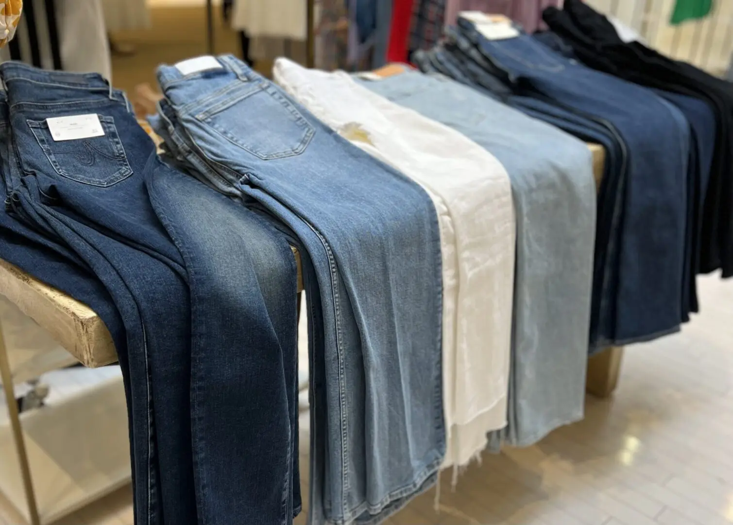 A display of pairs of jeans in various colors and styles